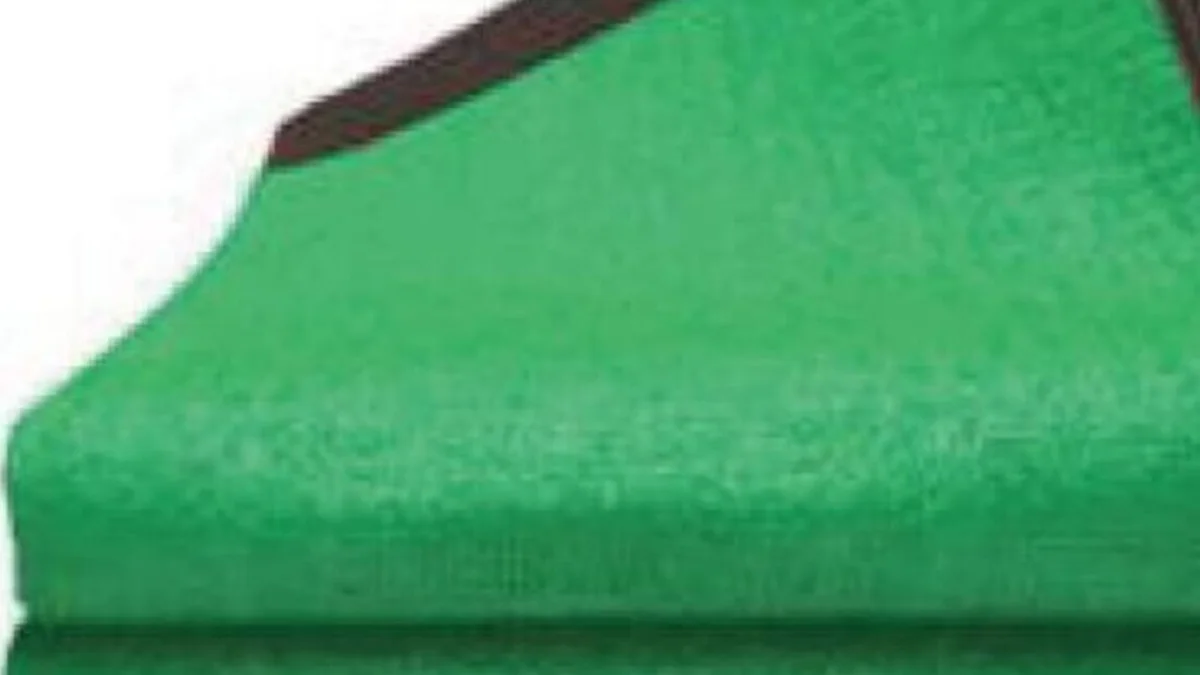 Folded green knitted shade net with a reinforced, grommeted edge